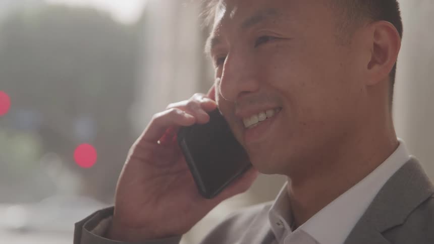 Smiling man talking on a smartphone on a call