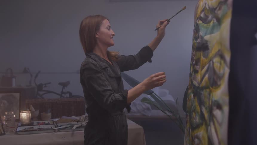 Woman painting on fabric in an indoor studio