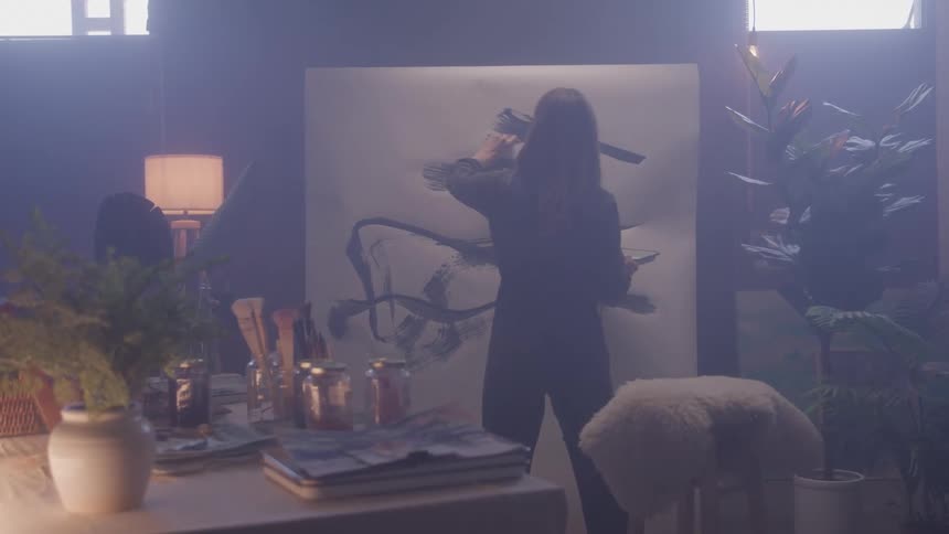 Woman standing painting on a whiteboard