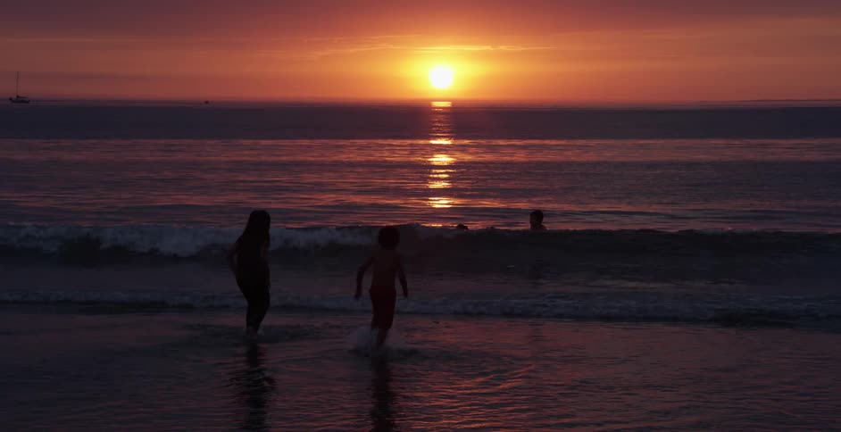 Children are playing in the water on the beach