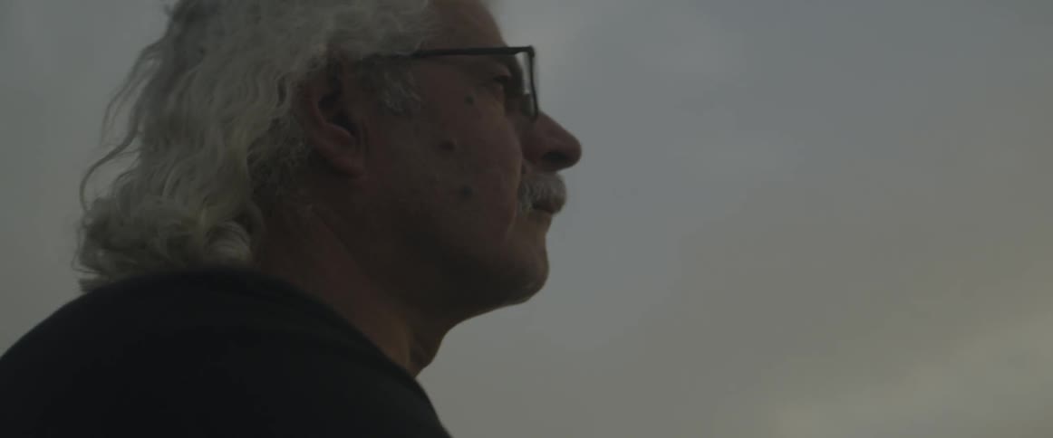 A man stands outdoors on an overcast day