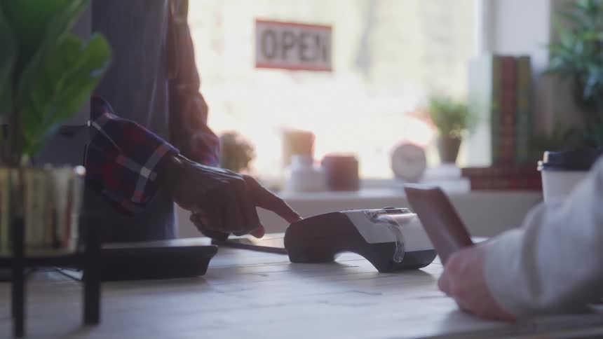 A person buying a coffee and paying with a credit card