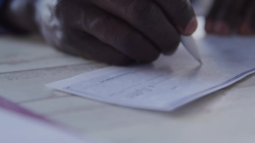 A man is filling out checks