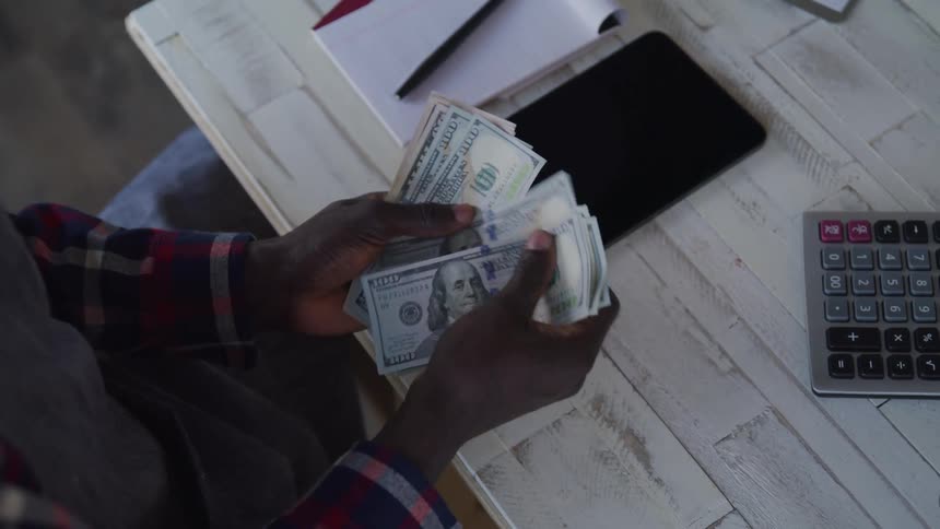 A cashier counts money on the counter at midday in the store