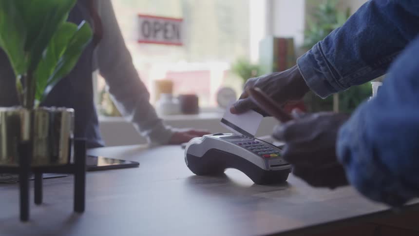 Customer swiping their card on a machine in an establishment