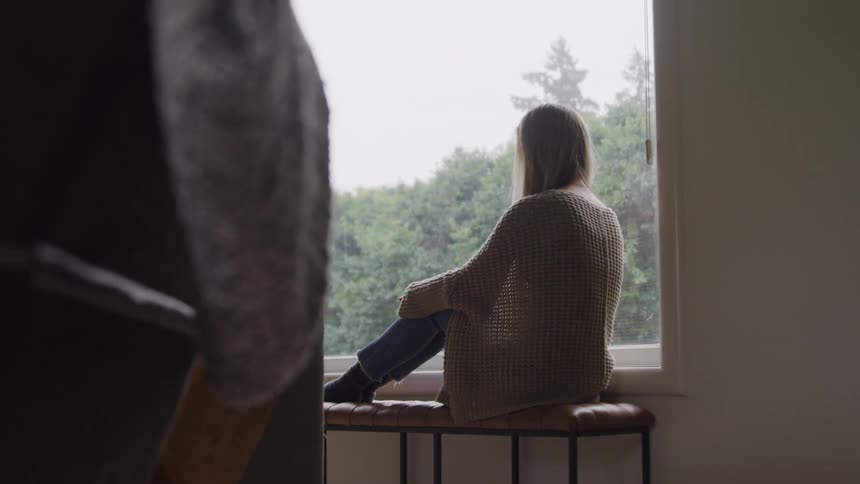 A woman looks out the window