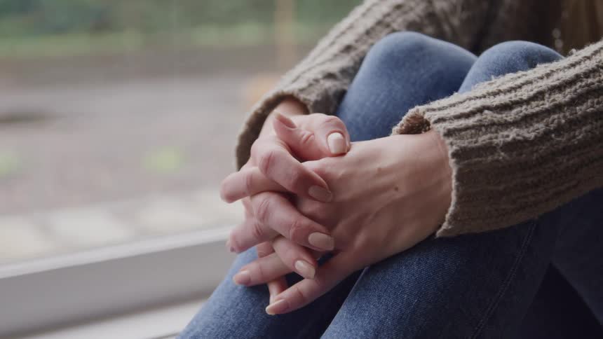 A woman is sitting by the window