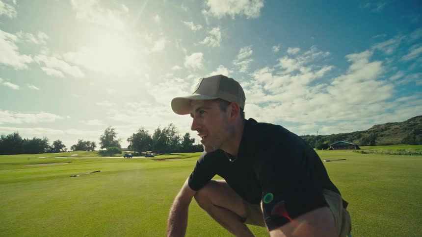 Man in cap crouching in a field