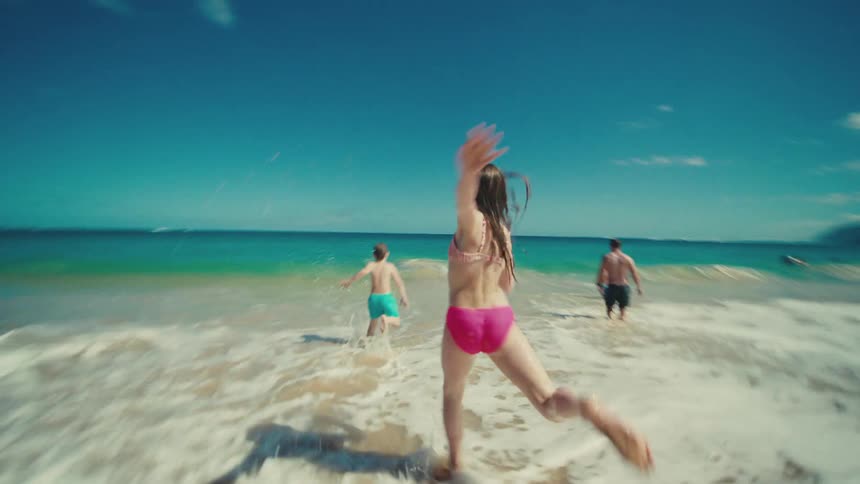 Children chase each other on the beach