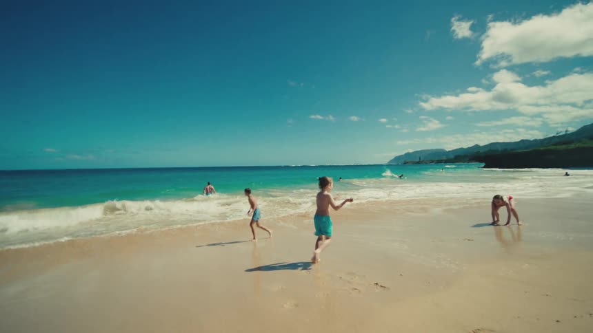 Children playing on the beach in a summer