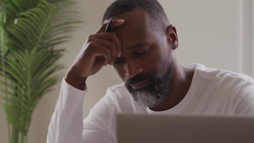 The man is holding a pen while reading