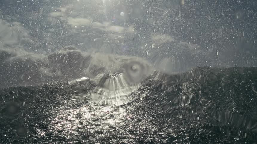 The wave makes water rain down off the shore