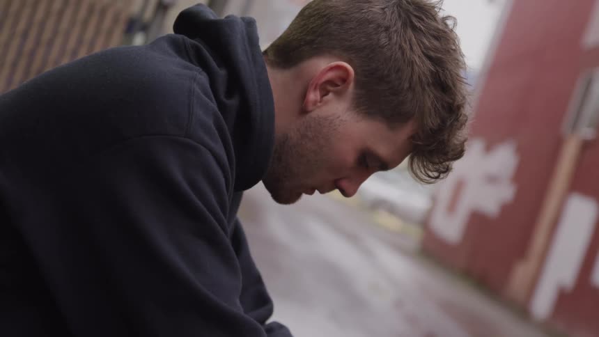 Man lowering his head outdoors