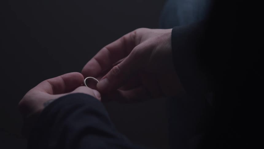 A person holds a ring between their fingers