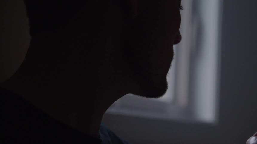 The man looks up by the window