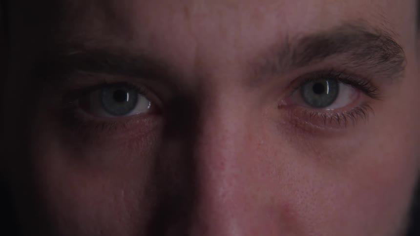 Male blue eyes in closeup stare directly with focus on the center of the face