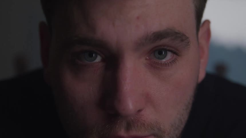 The man blinks his eyes and looks up