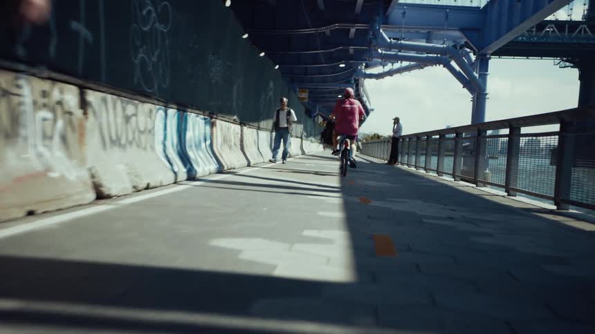 People walk and ride bicycles under the overpass