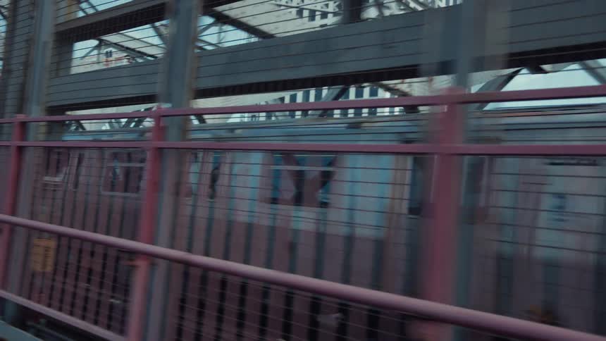 Public transit train travels across a structure in the city during the daytime