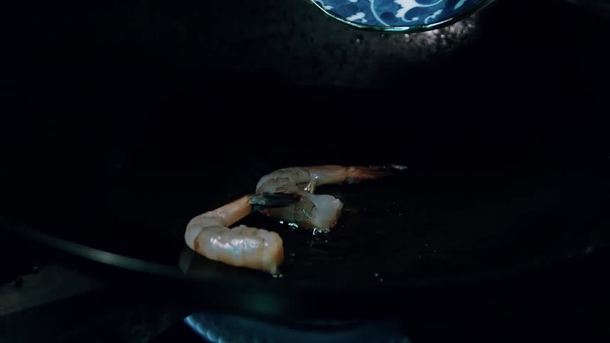 Shrimp are being cooked and fried on the stove