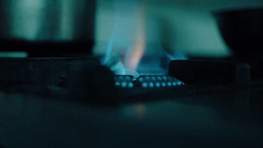 Close up of a person lighting up a gas cooker in the kitchen
