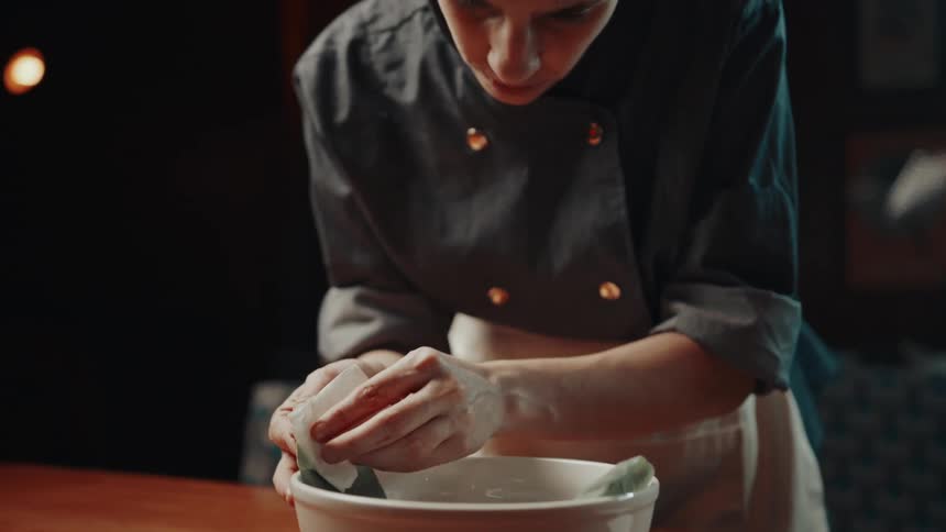 The chef is carefully plating a dish
