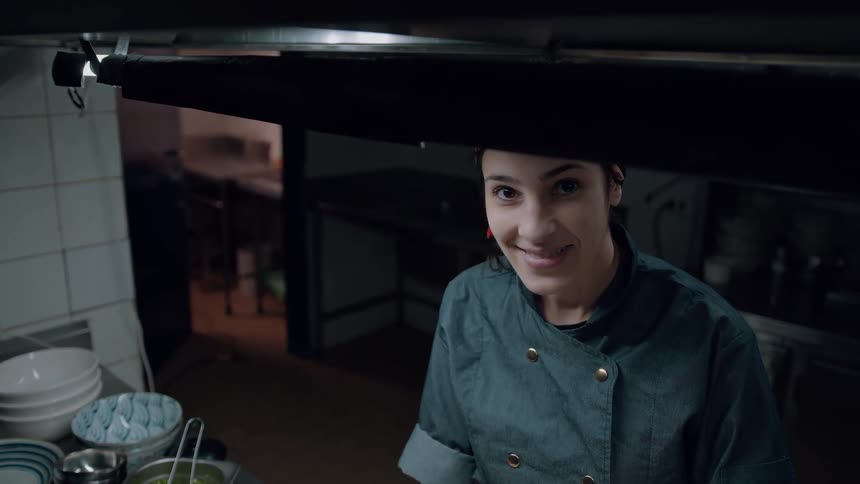 The chef smiles as she cooks