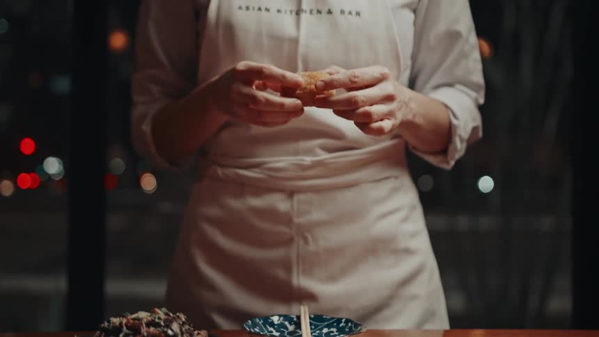 The chief picks up a piece of food from the plate