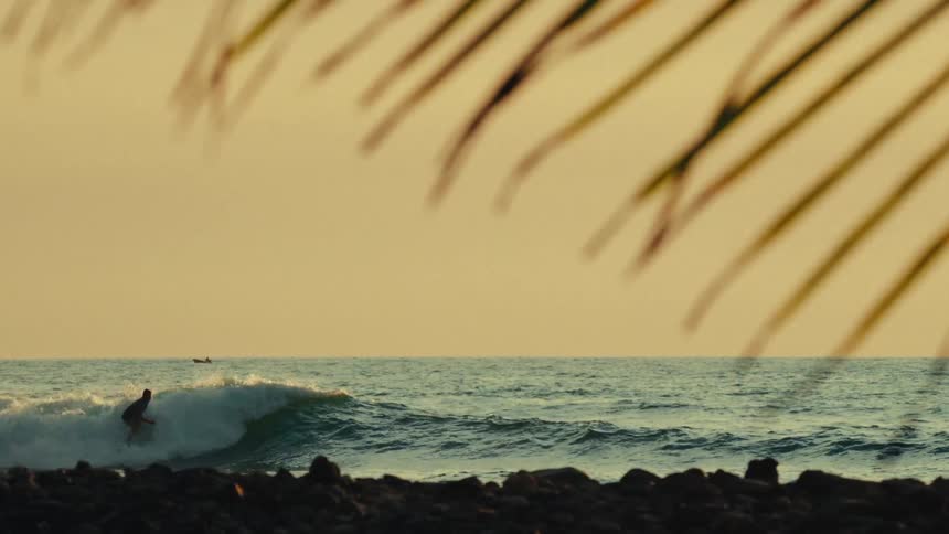 A man surfs waves in the ocean like a pro near the rocky shore