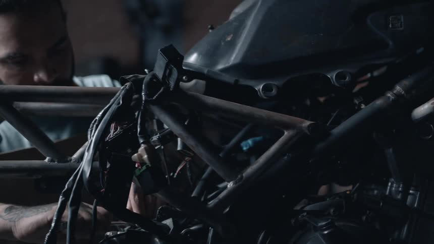 A mechanic works on a motorcycle in a mechanic workshop