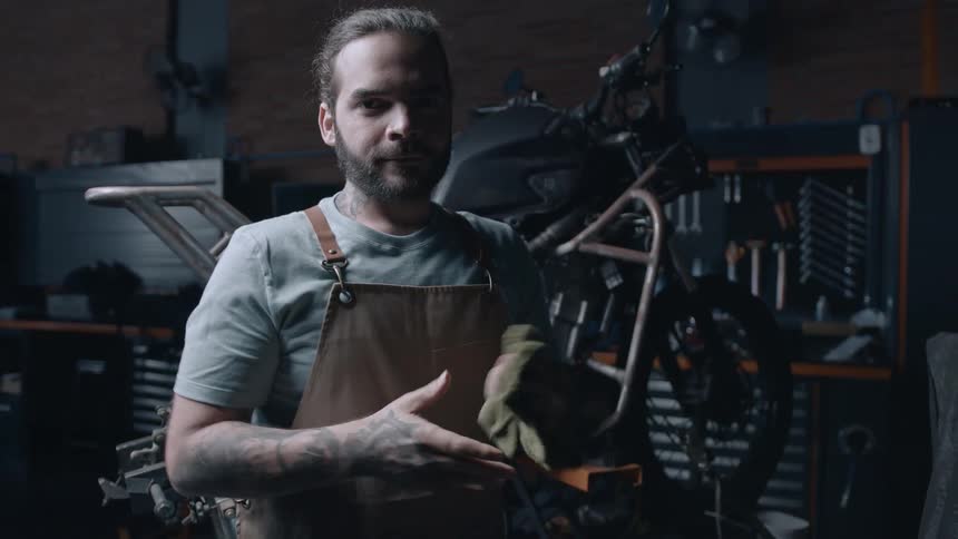 A mechanic wipes his hands with a rag