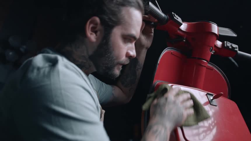 Man cleaning a red motorcycle