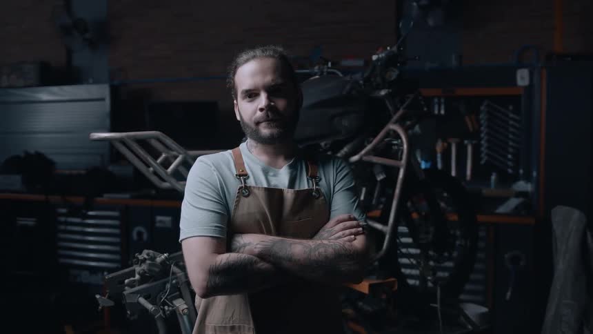 Mechanic crossing his arms inside a workshop