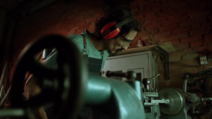 Concentrated man watching a machine in manual operation