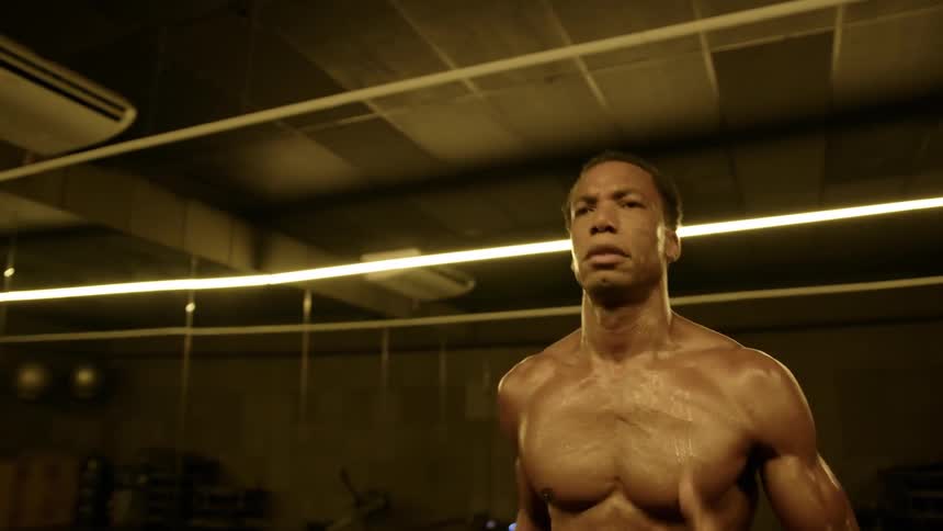 A young black man exercises in the gym