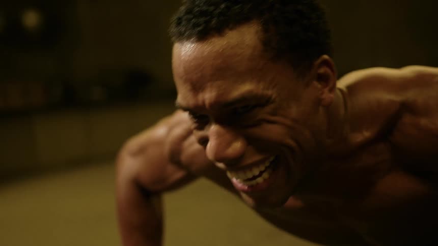 The man strains while doing push ups