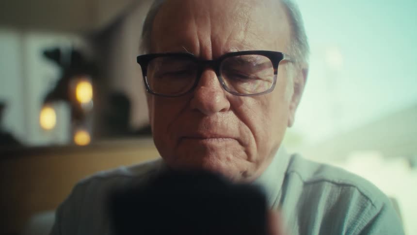 The man types on his cell phone at home
