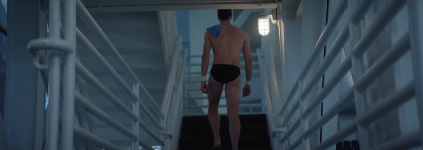 The swimmer is slowly climbing the steps in the building
