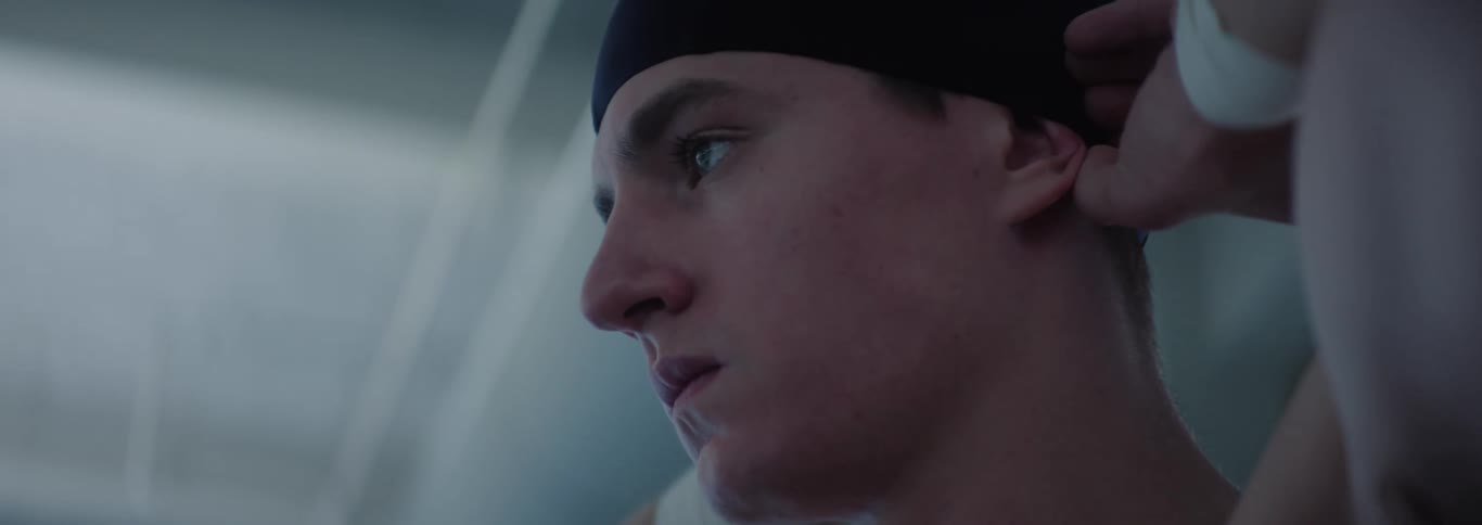 Man with determined expression adjusting swimming cap