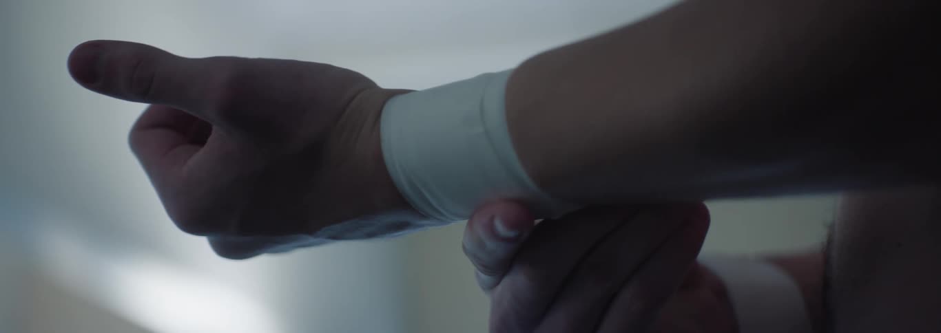 Person adjusting a white band on their wrist