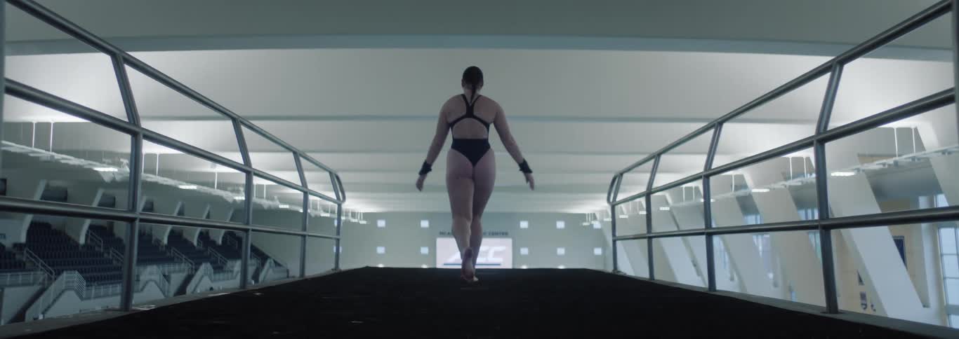 The swimmer does a flip diving off the platform