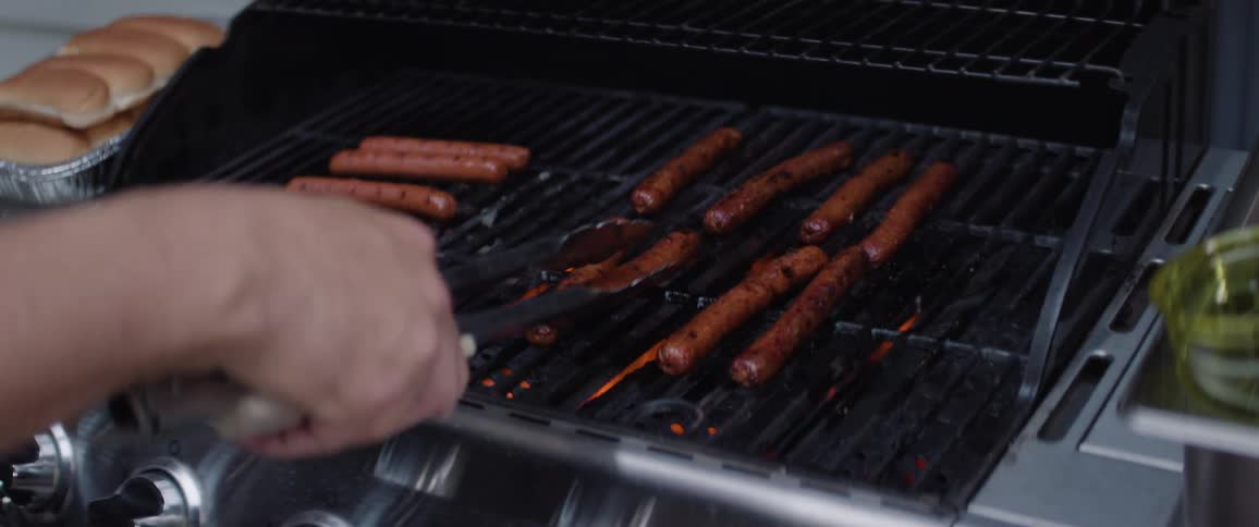 Cooking hot dogs outdoors on a bbq grill