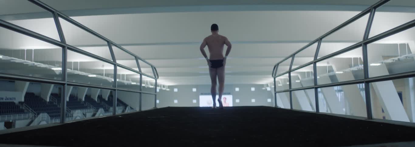 The swimmer walks down the long diving platform
