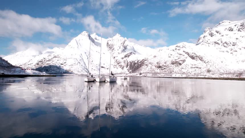 Three boats are anchored in the lake water
