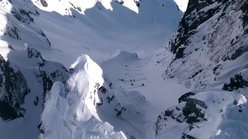 Group of skiers climbing a snowcovered mountain wall