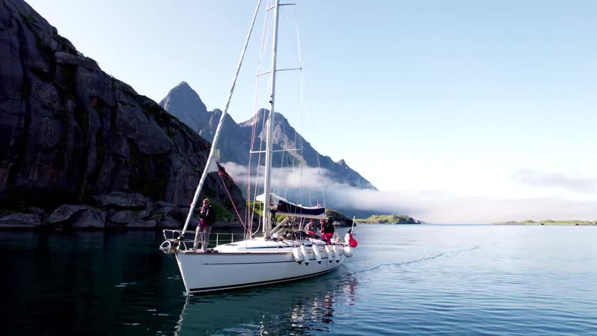 People are talking on the sailboat by the mountains