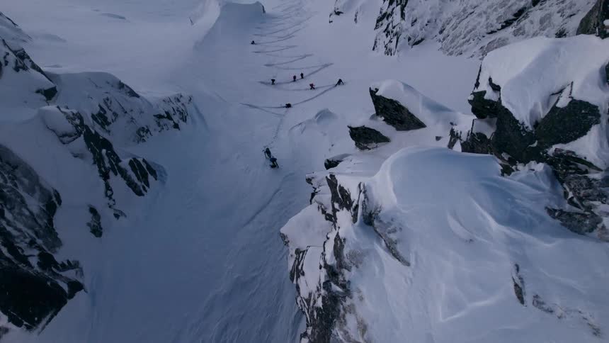 Group of people climbing a mountain wall covered by snow