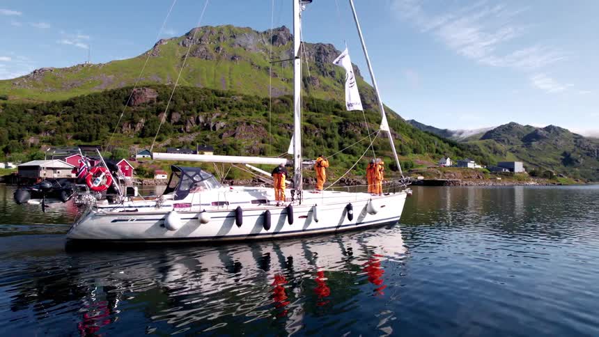 Group of people on a sailing boat with a mountain landscape in the background