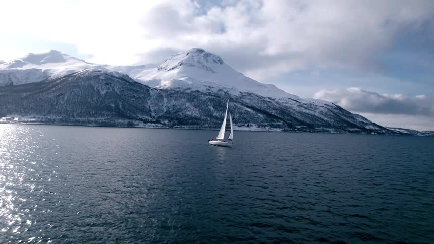 A boat on a lake near some snowy mountains