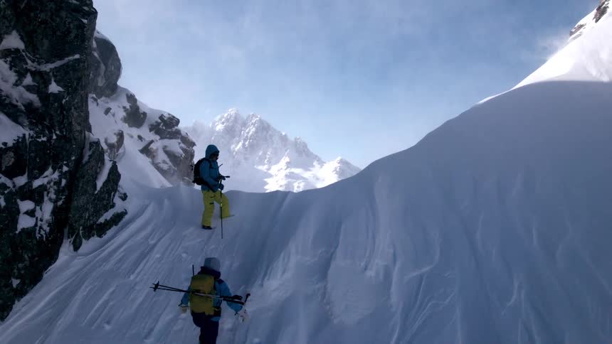 Two people climbing a steep snowcovered mountain